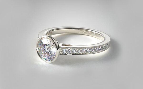 Bezel set engagement ring with pave set white gold band